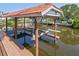 View of a covered boat lift with two boat slips on a canal at 77 Gulfwinds Dr, Palm Harbor, FL 34683
