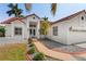 Charming home featuring lush landscaping, a red tile roof, and a welcoming entrance at 77 Gulfwinds Dr, Palm Harbor, FL 34683