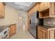 Bright kitchen with wooden cabinets, granite countertops, stainless steel refrigerator, and tile floors at 77 Gulfwinds Dr, Palm Harbor, FL 34683