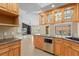 Kitchen with wood cabinets, granite counters, stainless steel appliances, and a breakfast bar at 77 Gulfwinds Dr, Palm Harbor, FL 34683