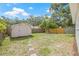 Spacious backyard with storage shed, mature trees, and partial wood fence at 7991 54Th N St, Pinellas Park, FL 33781