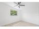 Empty bedroom with ceiling fan, large window, and light colored flooring at 7991 54Th N St, Pinellas Park, FL 33781