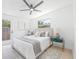 This bedroom features a ceiling fan, updated lighting, a door to the exterior, and a plush bed at 7991 54Th N St, Pinellas Park, FL 33781