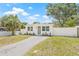 Inviting single-story home with white picket fence, updated windows, green door, and manicured landscaping at 7991 54Th N St, Pinellas Park, FL 33781
