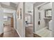A bright hallway featuring wood floors, leading to a bedroom and a laundry room at 8175 Sturbridge # 8175, Weeki Wachee, FL 34613