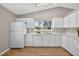 Bright kitchen featuring white cabinets, laminate countertops, and wood-look flooring at 8175 Sturbridge # 8175, Weeki Wachee, FL 34613