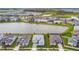 Overhead aerial view of a community with beautiful houses surrounding a stunning lake and lush greenery at 8192 Ivy Stark Blvd, Wesley Chapel, FL 33545