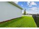 Well-maintained backyard with green grass, small tree and a view of the water at 8192 Ivy Stark Blvd, Wesley Chapel, FL 33545