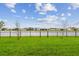 The fenced backyard offers green grass, a beautiful pond view, and surrounding homes at 8192 Ivy Stark Blvd, Wesley Chapel, FL 33545