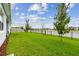 Beautifully landscaped backyard with lush green grass, trees, and a scenic water view at 8192 Ivy Stark Blvd, Wesley Chapel, FL 33545