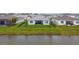 The backyard overlooks a serene lake, offering a peaceful retreat with a black fenced-in yard at 8192 Ivy Stark Blvd, Wesley Chapel, FL 33545