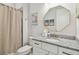 Bathroom with granite countertops, a decorative mirror, and a shower with a patterned curtain at 8192 Ivy Stark Blvd, Wesley Chapel, FL 33545