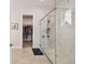 Bathroom featuring a spacious walk-in shower with glass enclosure and a walk-in closet in the background at 8192 Ivy Stark Blvd, Wesley Chapel, FL 33545