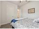 Bright bedroom with gray carpet and a bed with patterned bedding, with a door to an adjacent bathroom at 8192 Ivy Stark Blvd, Wesley Chapel, FL 33545