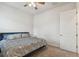 This cozy bedroom features carpet, a ceiling fan, a plush queen bed, and white walls at 8192 Ivy Stark Blvd, Wesley Chapel, FL 33545