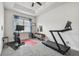 Bright bonus room features a ceiling fan, a window, and work-out equipment ready for a home gym at 8192 Ivy Stark Blvd, Wesley Chapel, FL 33545