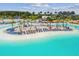 Aerial view of a sandy beach area with lounge chairs and umbrellas next to turquoise pool water at 8192 Ivy Stark Blvd, Wesley Chapel, FL 33545