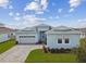 Charming light blue single-Gathering home with a two-car garage and well-manicured landscaping at 8192 Ivy Stark Blvd, Wesley Chapel, FL 33545
