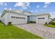Spacious three-car garage with paved driveway and lush landscaping at 8192 Ivy Stark Blvd, Wesley Chapel, FL 33545