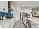 Spacious kitchen with white cabinets, stainless appliances, island with seating, and stylish blue backsplash at 8192 Ivy Stark Blvd, Wesley Chapel, FL 33545