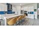 Modern kitchen boasts white cabinets, stainless steel appliances, quartz counters, and a stylish blue tile backsplash at 8192 Ivy Stark Blvd, Wesley Chapel, FL 33545