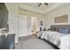 Well-lit main bedroom with a ceiling fan, plush carpet, and an ensuite bathroom with a glass-enclosed shower at 8192 Ivy Stark Blvd, Wesley Chapel, FL 33545