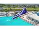 Aerial view of a large water slide, pool, seating area, and palm trees for a resort-style living at 8192 Ivy Stark Blvd, Wesley Chapel, FL 33545