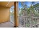 Private balcony with white railing, offering serene views of lush greenery at 9013 White Sage Loop, Lakewood Ranch, FL 34202