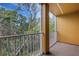 Private balcony with white railing, offering serene views of lush greenery at 9013 White Sage Loop, Lakewood Ranch, FL 34202