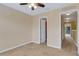 Bedroom with neutral carpet, door and ceiling fan, creating a peaceful and inviting ambiance at 9013 White Sage Loop, Lakewood Ranch, FL 34202