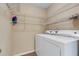 Convenient laundry area equipped with a washer, dryer, and shelving at 9013 White Sage Loop, Lakewood Ranch, FL 34202