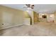 Carpeted living room with stairs and a ceiling fan at 9013 White Sage Loop, Lakewood Ranch, FL 34202