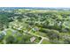 Stunning aerial view of a beautifully landscaped property, complete with a well-maintained lawn and mature trees at 9830 Caribou Trl, Dade City, FL 33525