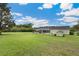 Long backyard showing lots of lawn, a storage shed and a screened in lanai with pool at 9830 Caribou Trl, Dade City, FL 33525