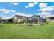 Wide view of the backyard, with fire pit, a picnic table and a screened in lanai with pool at 9830 Caribou Trl, Dade City, FL 33525