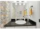 Well-lit bathroom with granite countertop, white cabinets, floral shower curtain, and modern fixtures at 9830 Caribou Trl, Dade City, FL 33525