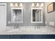 Bathroom featuring a double sink vanity with marble countertop, two mirrors, and modern lighting at 9830 Caribou Trl, Dade City, FL 33525