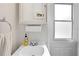 Bright bathroom featuring a classic vanity with white porcelain sink, medicine cabinet, and natural light from a nearby window at 9830 Caribou Trl, Dade City, FL 33525