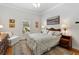 Inviting bedroom with hardwood floors, a patterned rug, and a serene landscape painting over the wood headboard at 9830 Caribou Trl, Dade City, FL 33525