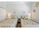 Cozy bedroom features twin beds with floral bedding, bedside tables and lamps, perfect for guests or children at 9830 Caribou Trl, Dade City, FL 33525