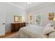 Bright bedroom with a window with blinds, rich hardwood floors, and a cozy seating area at 9830 Caribou Trl, Dade City, FL 33525