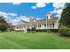 Exterior view of this home with an expansive lawn, mature trees, and a welcoming front porch at 9830 Caribou Trl, Dade City, FL 33525