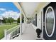 Charming covered porch with white railings and a view of the manicured front yard at 9830 Caribou Trl, Dade City, FL 33525