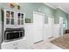 Hallway featuring wainscoting, a microwave cabinet, and neutral paint colors at 9830 Caribou Trl, Dade City, FL 33525