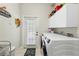 Laundry room with a door to the backyard and white washer and dryer at 9830 Caribou Trl, Dade City, FL 33525