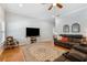Cozy living room with hardwood floors, a ceiling fan, and comfortable seating arrangements at 9830 Caribou Trl, Dade City, FL 33525