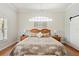 Charming main bedroom features a high, arched window and a decorative wooden headboard at 9830 Caribou Trl, Dade City, FL 33525