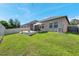 A spacious backyard with a concrete pad, outdoor furniture, lush green grass, and a secure privacy fence at 11314 American Holly Dr, Riverview, FL 33578