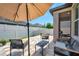 A tiled outdoor space with an umbrella and cozy seating offers a perfect spot for relaxation and enjoying the outdoors at 11314 American Holly Dr, Riverview, FL 33578
