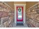 Elegant front door with a decorative wreath, framed by stone walls at 11314 American Holly Dr, Riverview, FL 33578